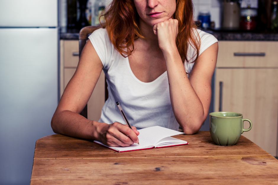 Young woman writing a list of questions before a pelvic floor physio appointment.